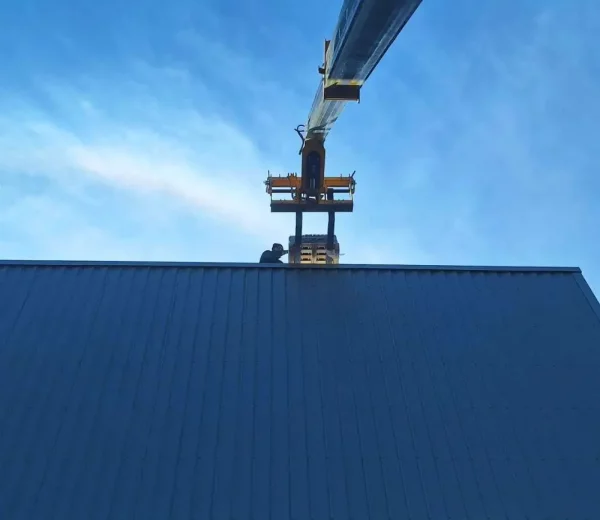 Technicien photovoltaique qui réceptionne une palette de panneaux photovoltaïques sur un toit
