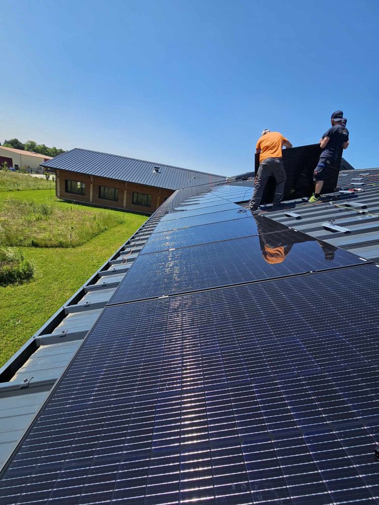Deux installateurs photovoltaïques de chez Sol'Air Energie entrain de poser des panneaux solaires chez ABC Informatique, entreprise valentinoise