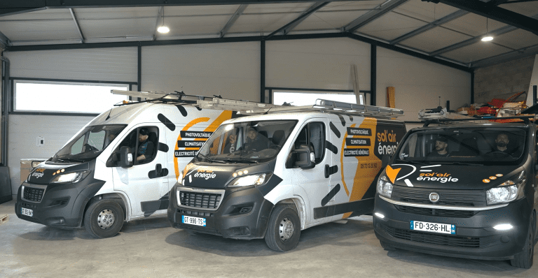 Trois camions floqués "Sol'Air Energie" dans le dépôt près à partir.