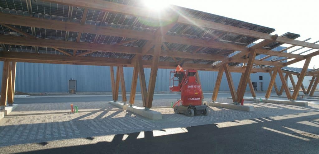 Technicien Photovoltaïque qui travaille sur l'installation d'une Ombrière