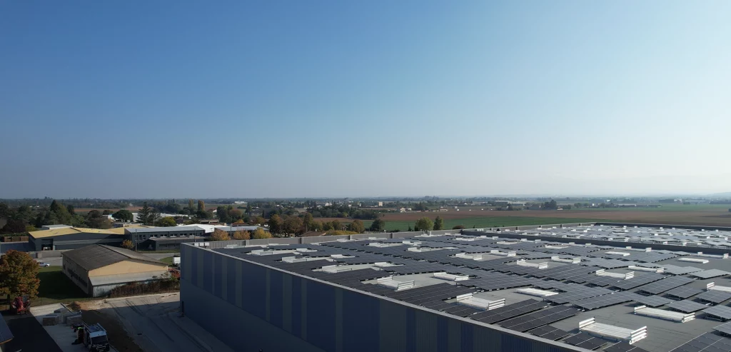 Grande entreprise dans la zone industrielle de Valence équipée en panneaux Photovoltaïques sous un ciel bleu.