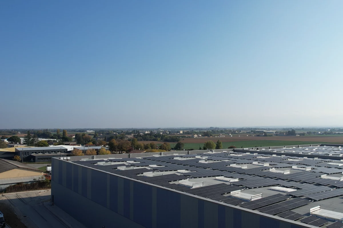 Grande entreprise dans la zone industrielle de Valence équipée en panneaux Photovoltaïques sous un ciel bleu.