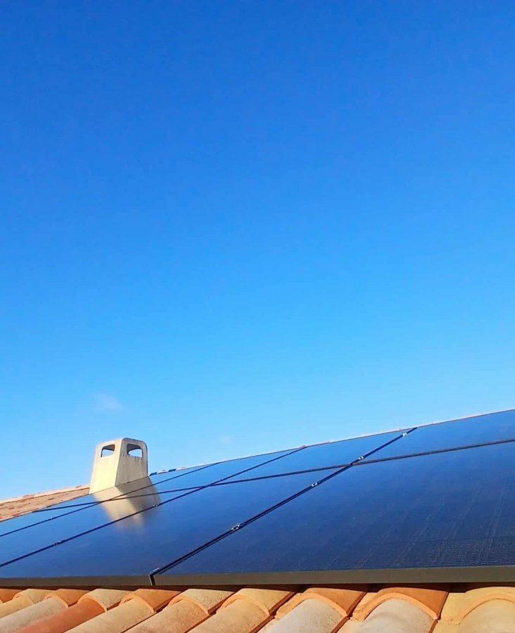 8 panneaux photovoltaïques posés sur un toit tuile sois un ciel bleu
