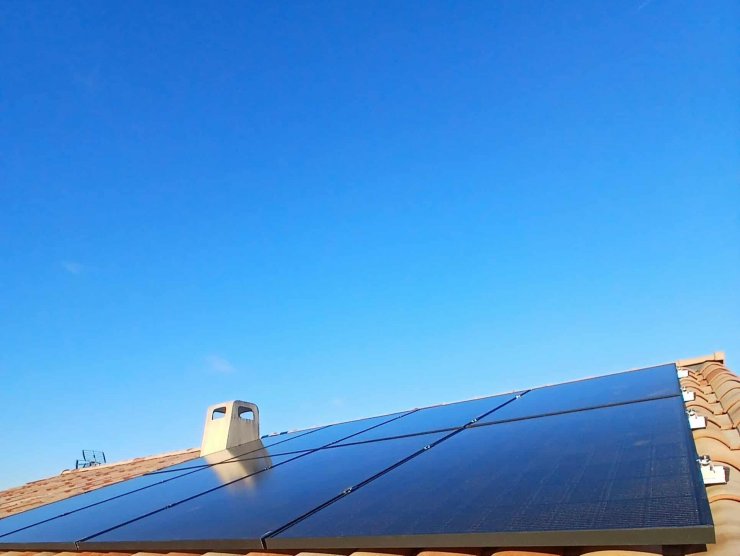 8 panneaux photovoltaïques posés sur un toit tuile sois un ciel bleu