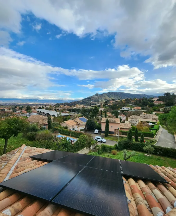Cinq panneaux solaires sur le toit d'une habitation sous un ciel ensoleillé