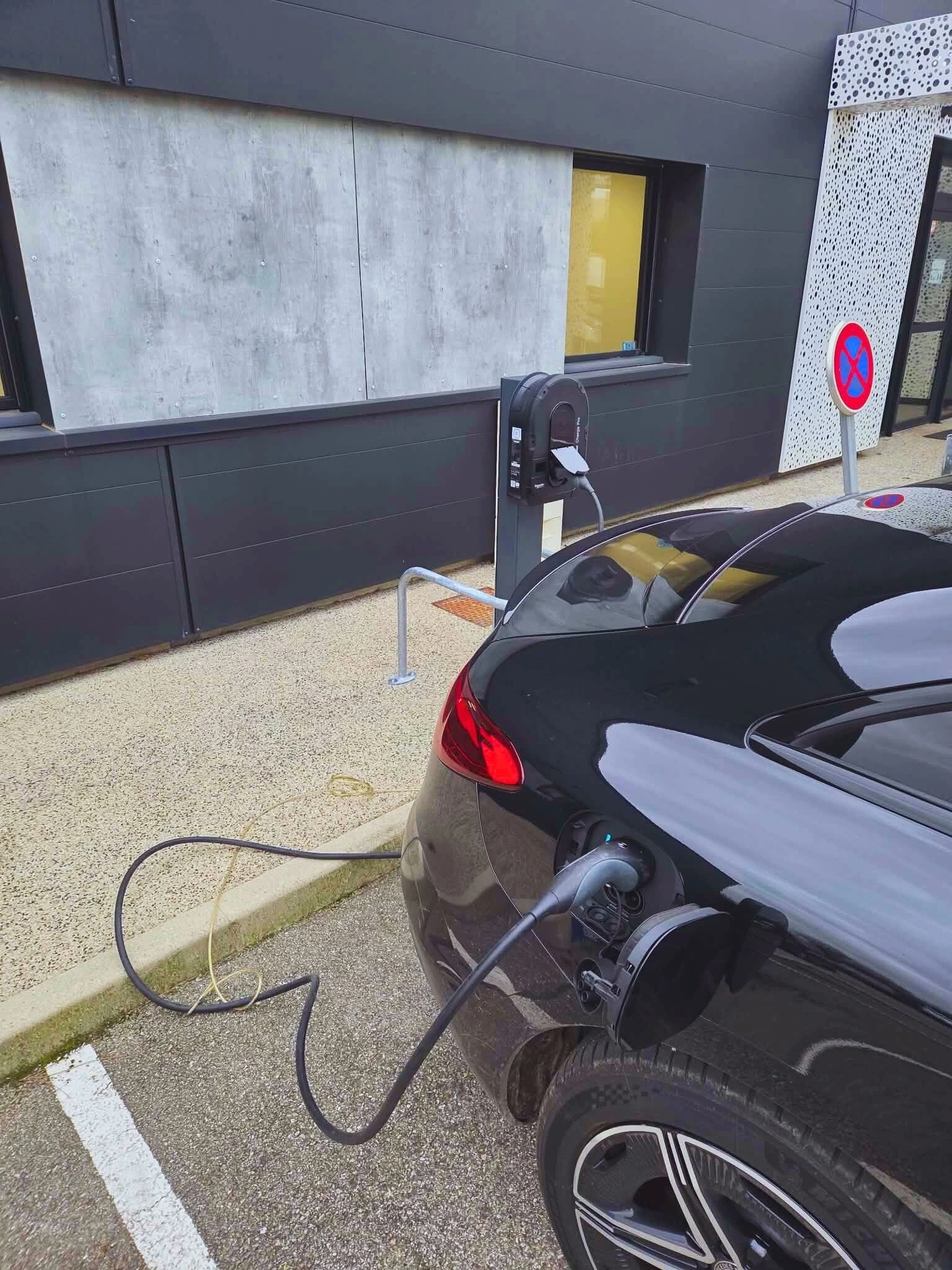 voiture électrique branchée à une borne de charge sur un parking public