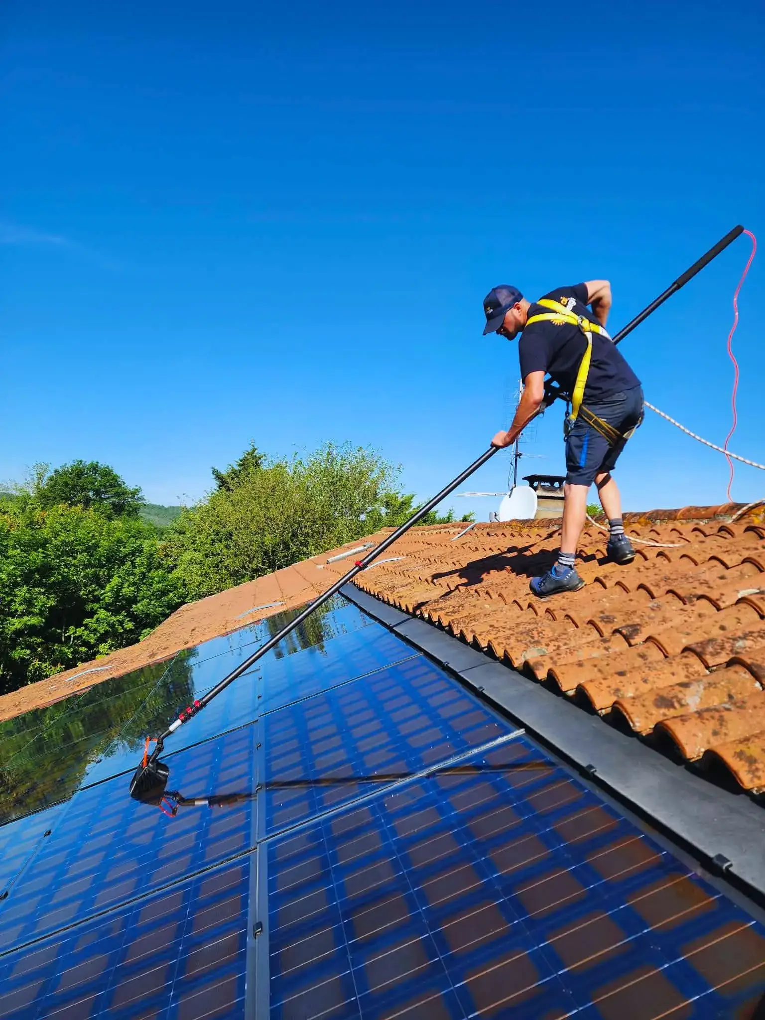Technicien, qui nettoie des panneaux photovoltaïques à la brosse souple