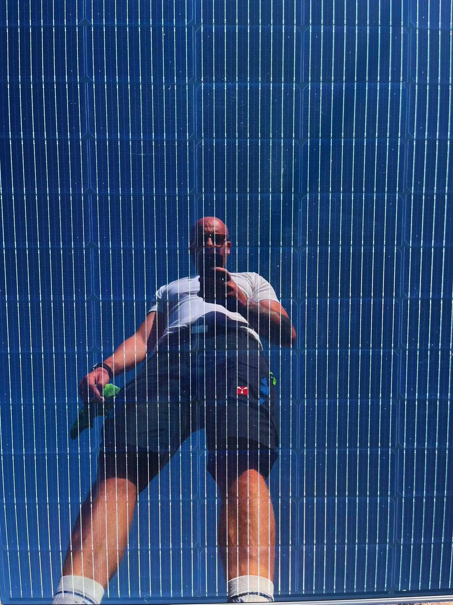technicien photovoltaïque dans le reflet d'un panneau solaire photovoltaïque