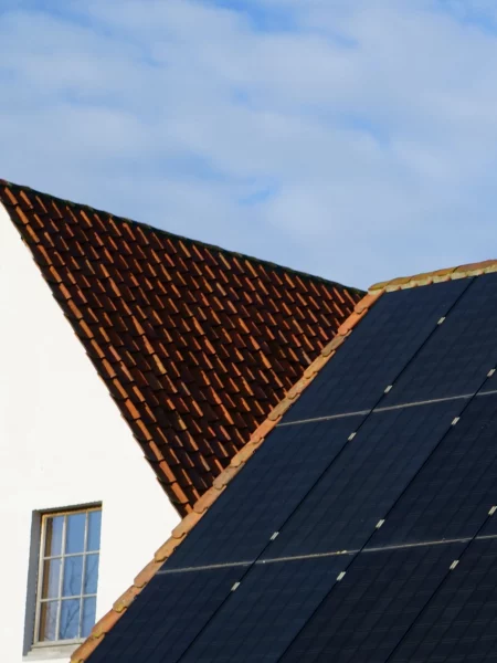 Panneaux photovoltaïques posés sur un toit en pente avec des tuiles.