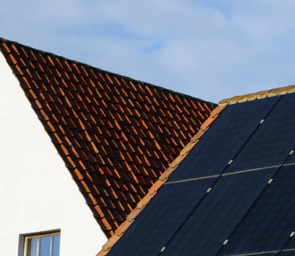 Panneaux photovoltaïques posés sur un toit en pente avec des tuiles.
