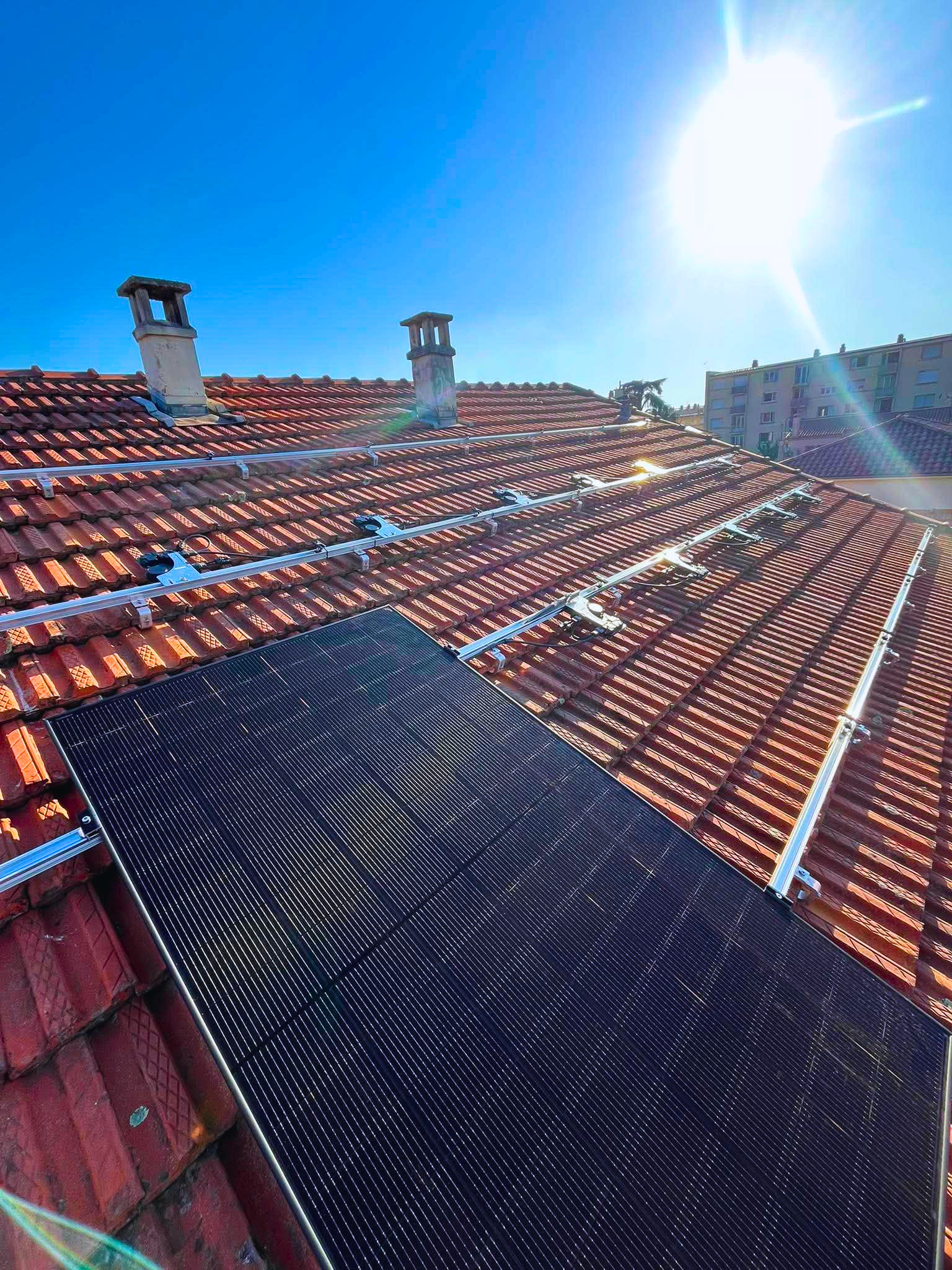 Installation photovoltaïque en cours. Un panneau solaire est posé sur la strucure K2 Systems et les micro-onduleurs Enphase sont fixés