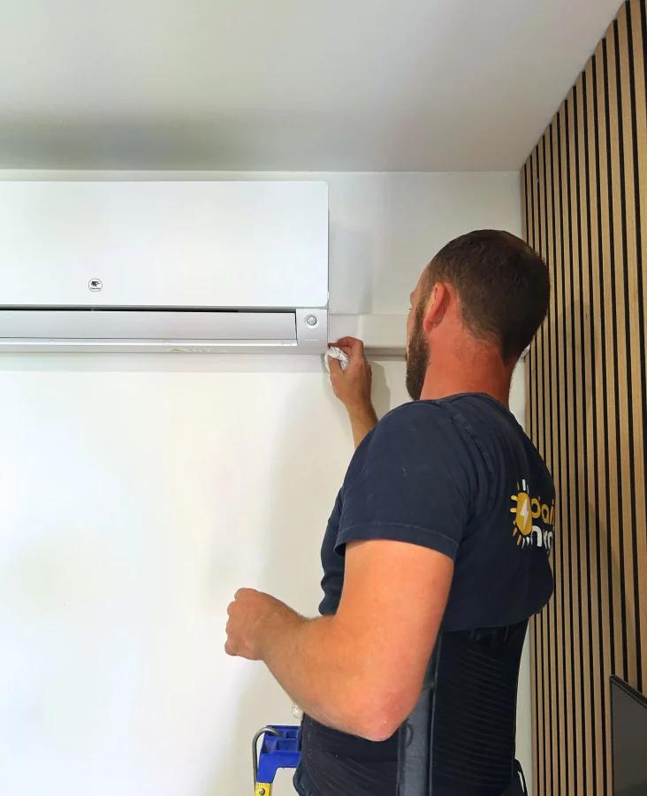 Michel, technicien électricien chez sol'air energie nettoie la climatisation intérieure qui vient d'être posée