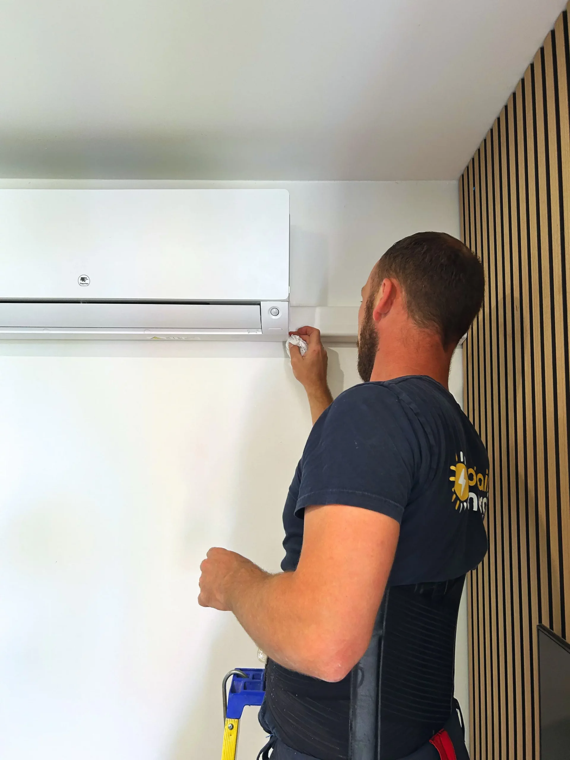 Michel, technicien électricien chez sol'air energie nettoie la climatisation intérieure qui vient d'être posée