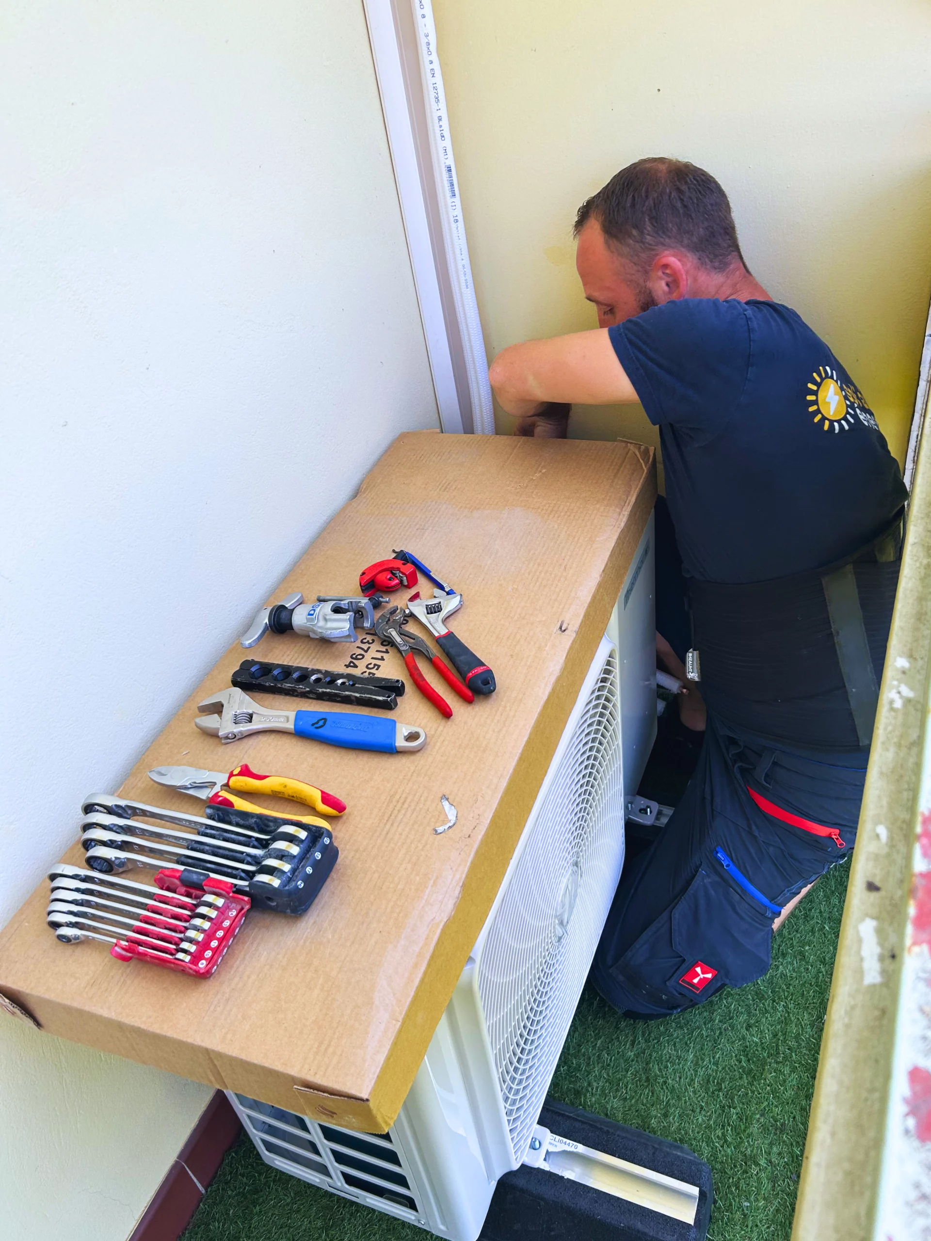 Michel, électricien technicien chez sol'air energie installe l'unité extérieur du climatiseur